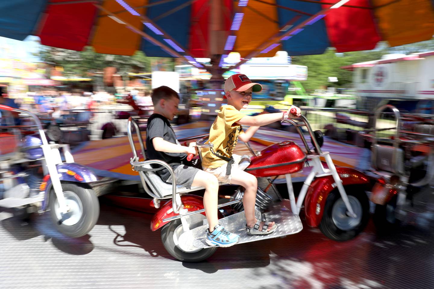 Pierce Cole, 5, (right) and Conrad Hylton, 5, both of Geneva, ride a motorcyle carnival ride during opening day of Swedish Days Festival in Geneva on Wednesday, June 22, 2022. The festival runs through Sunday, June 26, 2022.