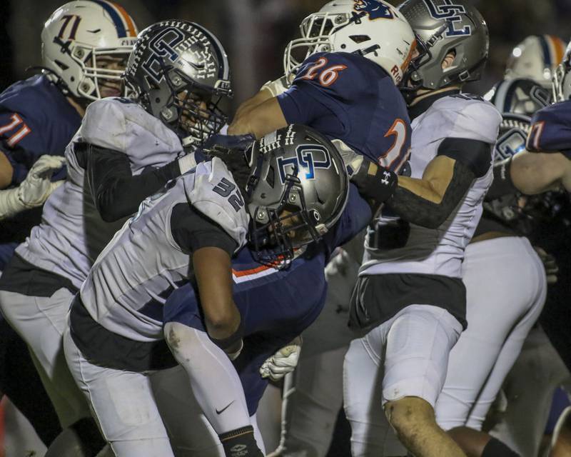 Oswego's Dekker Zelensek (26) is gang tackled by the Oswego East defense led by Jeremy Rivers (32) during football game between Oswego East at Oswego Friday, Oct 17, 2025 in Oswego.