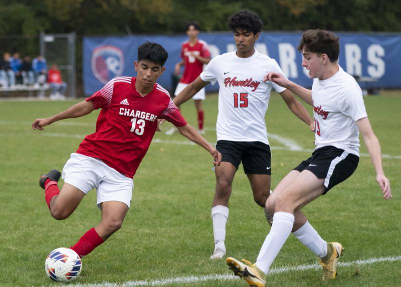 Dundee-Crown's Christian Lechuga looks to pass past Huntley's Ansel Dias, middle, and Anthony Aweve during their game on Thursday, October 6, 2022 at Dundee-Crown High School in Carpentersville. Dundee-Crown won 1-0.