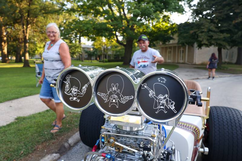 Cartoon character Yosemite Sam is the theme of the front engine dragster custom built by Neil Hambly, right, of Yorkville, as seen during the Cruise-In Night at the Museum on Thursday, Aug. 14, 2025. Inspired by 70's drag racing and his childhood love for the cartoon characger, Neil and his wife, Ronna, left, began bringing the 2-seater car to shows upon its completion about two and a half years ago.