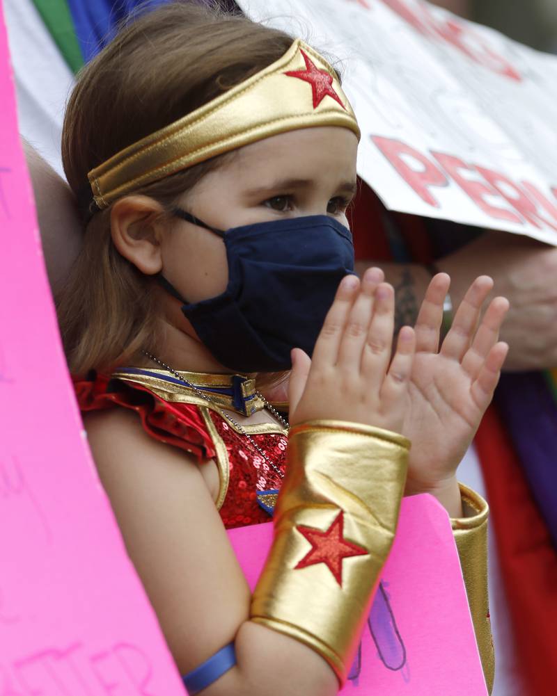 Patricia Mykisen, 5, of Woodstock, claps for speakers while dressed as Wonder Woman during a rally for abortion rights on the historic Woodstock Square on Saturday, Oct. 2, 2021, in Woodstock.