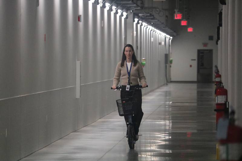 A Meta employee demonstrates how workers use scooters to get around the vast corridors inside the Meta DeKalb Data Center, 2050 Metaverse Way, DeKalb on Wednesday, Nov. 29, 2023. The 2.3 million-square-foot campus was built with sustainability in mind, with cooling technology and specialized concrete created with the aid of artificial intelligence among other features.