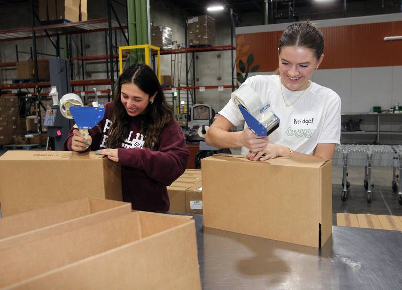 Olivia Balos and Bridget Graham, both 17, of Libertyville and best friends, make boxes to store canned peas at the Northern Illinois Food Bank on August 19th in Lake Forest. The North Suburban Center recently celebrated it’s one-year anniversary.  
Photo by Candace H. Johnson for Shaw Local News Network