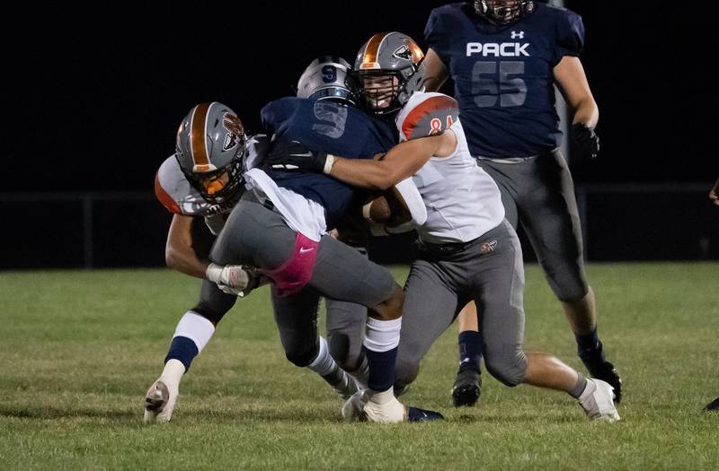 Minooka's Isaiah Dupree (left) and Will DeBold (84) hit Oswego East's Tre Jones (9) in the backfield for a loss during a varsity football game at Oswego East High School in Oswego on Friday, Oct 1, 2021.