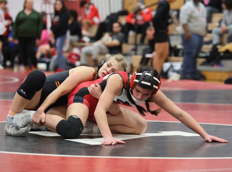 Yorkville's Athena Westphal, in red, goes up against against Minooka's Kira Cailteux during the Southwest Prairie Conference wrestling meet at Yorkville High School on Saturday, Jan. 21, 2023.