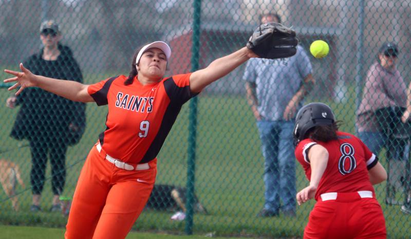 St. Charles East’s Cici Wilson, left, reaches for the throw at first base as Huntley’s Zoe Doherty steps in safely during varsity softball at Marengo Saturday morning.