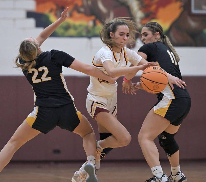 Montini’s Nikki Kerstein breaks through the double-team defense of Neuqua Valley’s Taylor Dobry and Quinn Segal, right, in a girls basketball game at Montini Catholic High School in Lombard Monday.