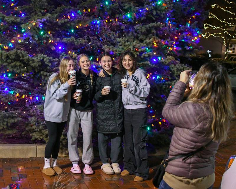 Friends (from left) Aleena Vogel, a high school junior, eighth grader Jenna Vogel, eighth grader Angelina Caballero, and high school junior Julia Caballero, all from DeKalb, pose for a photo taken by Lisa Vogel in front of the downtown DeKalb Christmas tree during the DeKalb Chamber of Commerce's annual Lights on Lincoln and Santa Comes to Town event held in downtown DeKalb on Thursday, Nov. 30, 2023.
