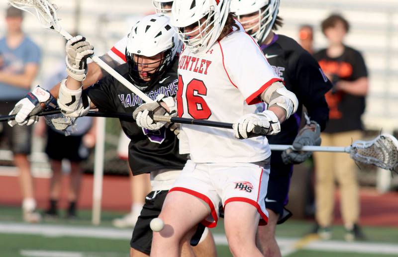Huntley’s Kelley Gassner, right, battles Hampshire’s Jack Gawlik in varsity lacrosse at Huntley Thursday night.