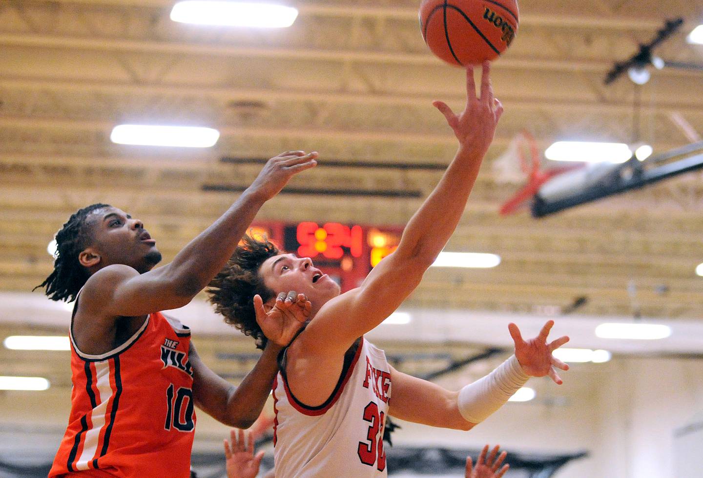 Yorkville's Bryce Salek makes a breakaway layup and get the foul by Romeoville defender Aaron Brown (10) during a boys' basketball game at Yorkville High School on Tuesday, Jan. 10, 2023.