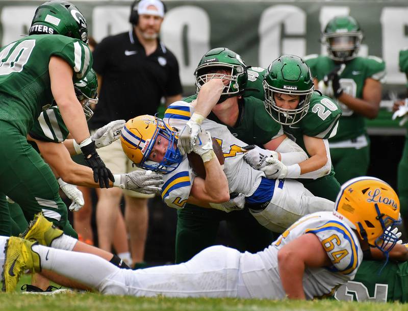 Several Glenbard West tacklers including Joey Campanella (20) team up to stop Lyons Township running back Danny Caroll (5) during a game on Sep. 16, 2023 at Glenbard West High School in Glen Ellyn.