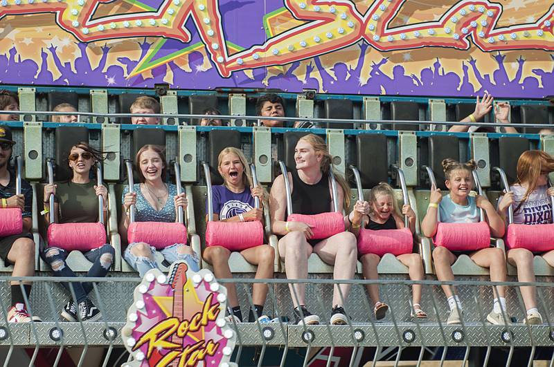 Riders scream and hold on as the “Rock Star” ride circles the air at Dixon’s Petunia Fest carnival on Thursday, June 30, 2022.