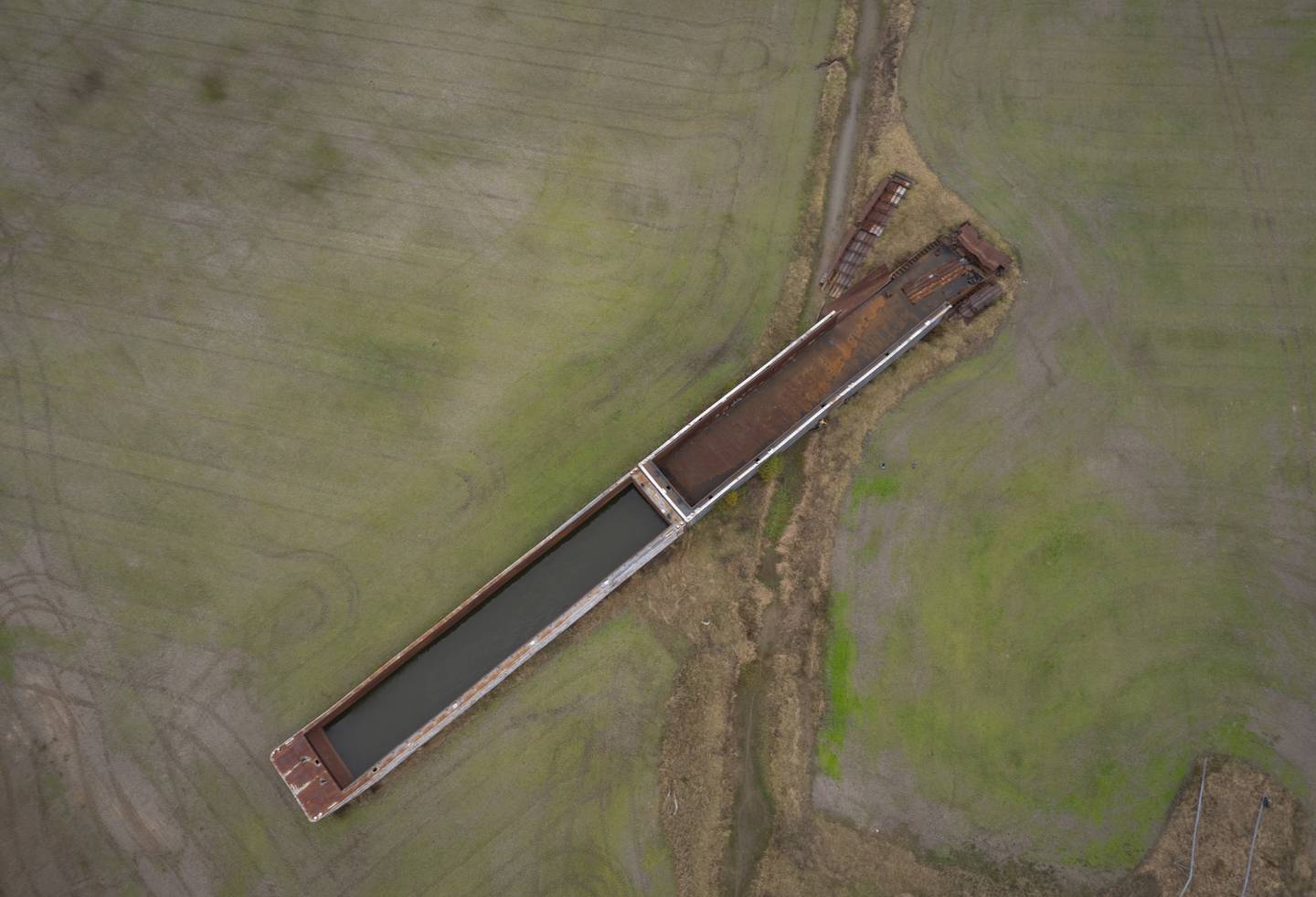 A historic flood in 2019 broke through the Len Small Levee that protected Dogtooth Bend, sending six barges floating onto the land. Two remain in a field, seen here in November 2024.