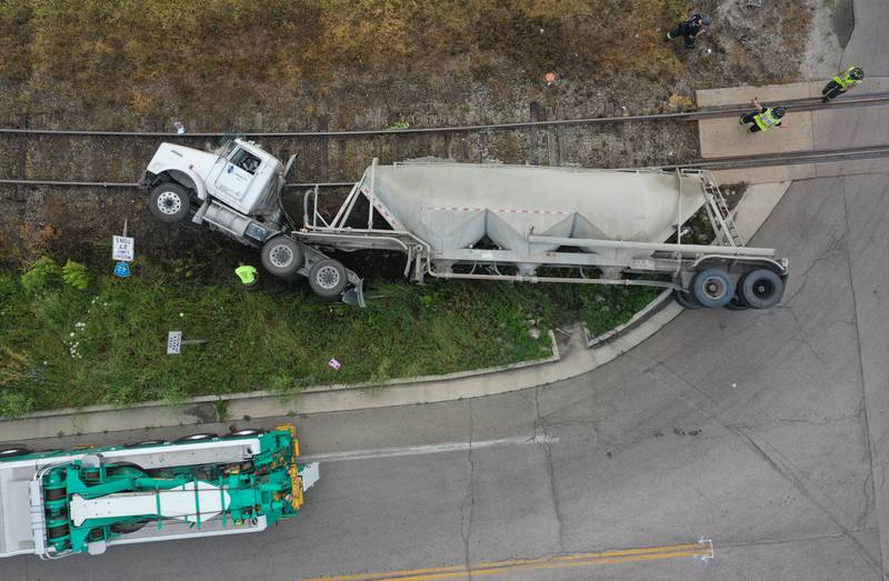 Wallace firefighters work the scene of an overturned sand hauler at the intersection of North 15th Road and U.S. Route 6 on Wednesday, July 9, 2025 in Ottawa. The semi overturned on the train tracks. La Salle County Sheriff and Ottawa Police assisted with the crash.