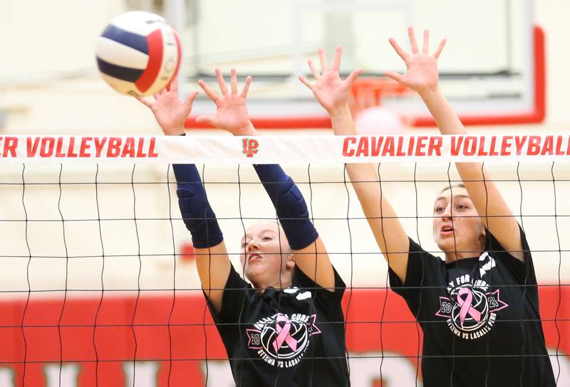 Ottawa's Skylar Dorsey and teammate Addison Duggan block a spike from L-P during Volley for a Cure night on Tuesday, Oct. 1, 2024 at AJ Sellett Gymnasium.