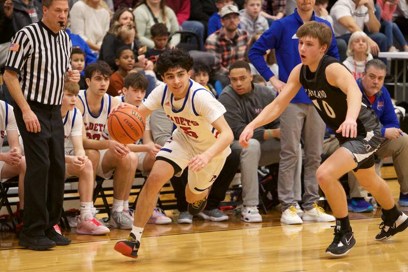 Marmion Academy's Jacob Piceno drives the baseline against Kaneland's Troyer Carlson at the Class 3A Regional Final at Kaneland on Saturday, Feb.25, 2023.