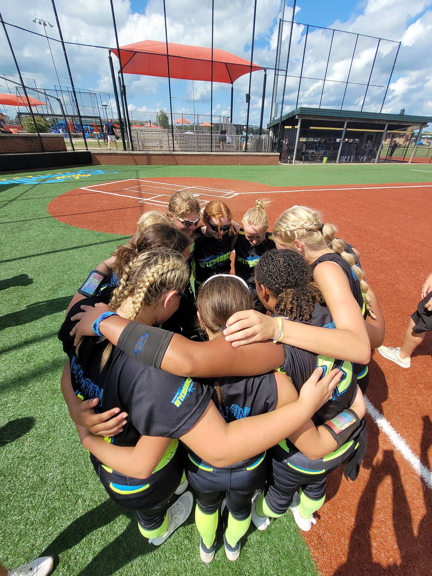 The Midwest Aftershock 16U travel team huddles up after winning the title at the USSSA Great Lakes Nationals in Evansville, Indiana, in July.