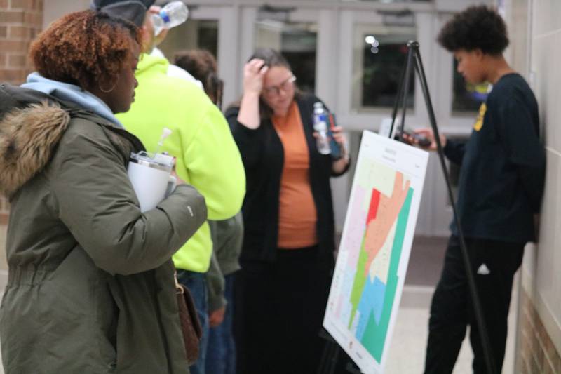Attendees take a glance at the final attendance boundaries presented during a Jan. 9, 2025, community conversation held at DeKalb High School.