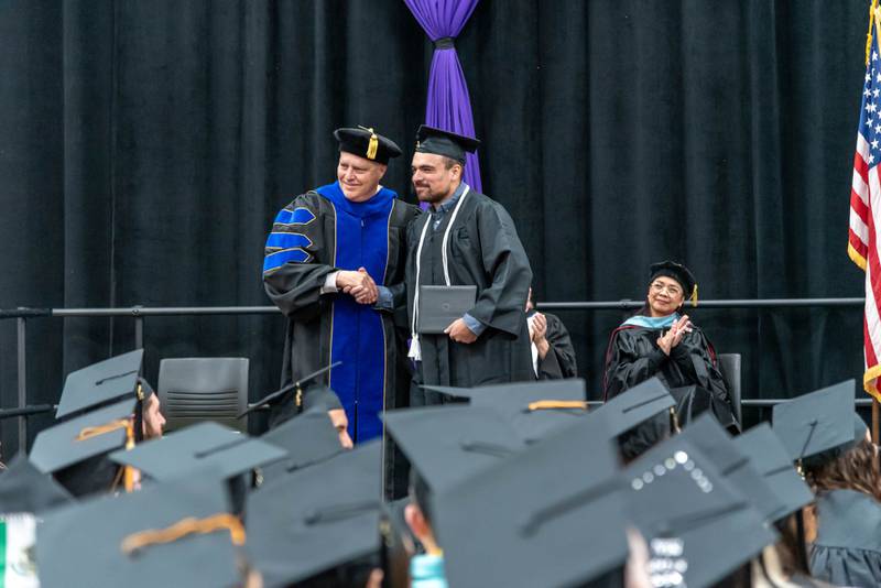 McHenry County College President Clint Gabbard shakes hands with a new graduate at MCC’s winter commencement ceremony on Saturday, Dec. 10, 2022.