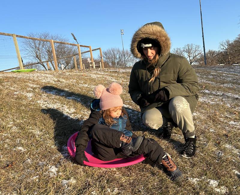 Amari Orellana, 5, of Naples, Florida, gets some help from her mom, Hannah, as she rides a saucer sled down the hill at Winter Park in Morrison on Friday, Jan. 3, 2025. Amari and her family were visiting relatives in Morrison and wanted to try sledding following the dusting of snow that fell across the region.