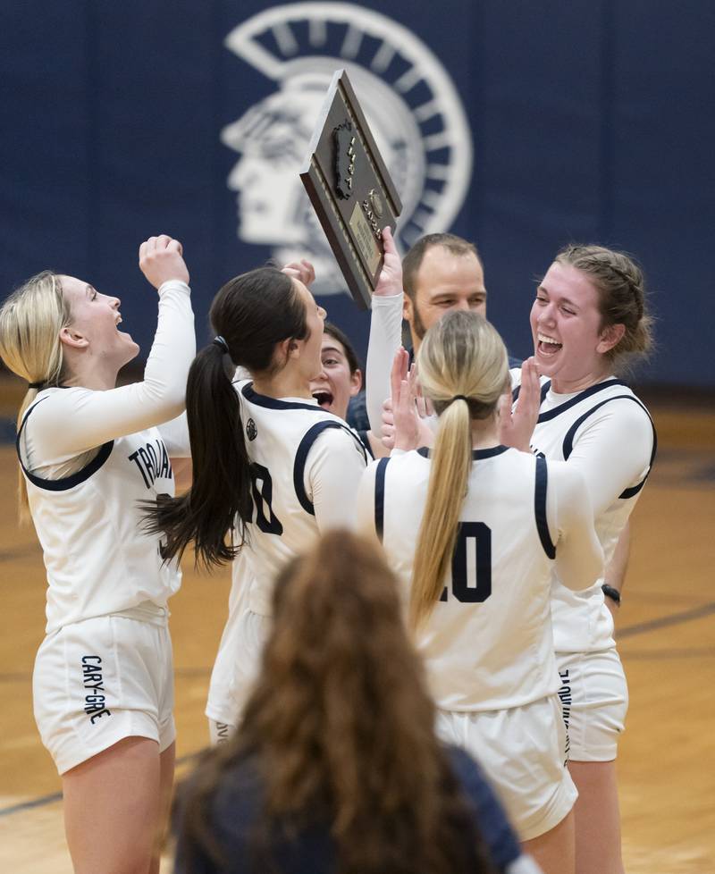 Cary-Grove's Ellie Mjaanes, far right, holds the championship trophy as she celebrates with teammates after defeating Lake Forest at the Class 3A Cary-Grove Regional Girls Basketball Championship game on Thursday, February 20, 2025 in Cary. Ryan Rayburn for Shaw Local