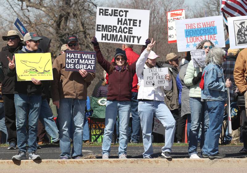 Protesters line Sycamore Road in front of Hopkins Park in DeKalb Saturday, March 28, 2026, during a No Kings march and rally against the federal actions of President Donald Trump and his administration.