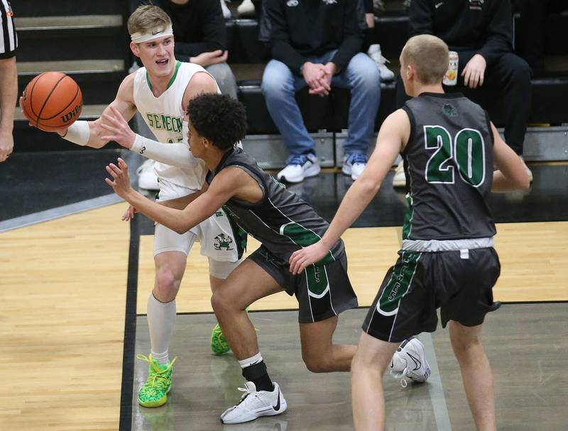 Seneca's Paxton Giertz looks to pass the ball off as he runs baseline with Midland's Deshaun Brown during the Tri-County Conference Tournament on Thursday, Jan. 25, 2024 at Putnam County High School.