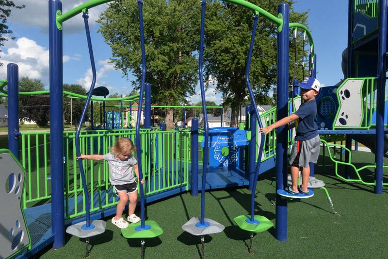 Chandler Fullick, 7, and his sister, Sophia, 3, of Clinton, Iowa, play on the new playground equipment at School Park in Fulton on  Saturday, July 6, 2024.