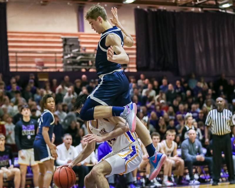 Downers Grove South's Will Potter (2) flips over Downers Grove North's Aidan Akkawi (24) during basketball game between Downers Grove South at Downers Grove North. Dec 16, 2023.