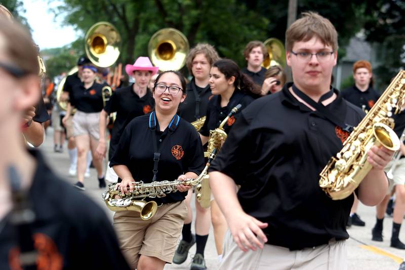 The Marching Warriors run to greet parade goers as the Fiesta Days Parade makes its way down Main Street in McHenry on Sunday, July 20, 2025.