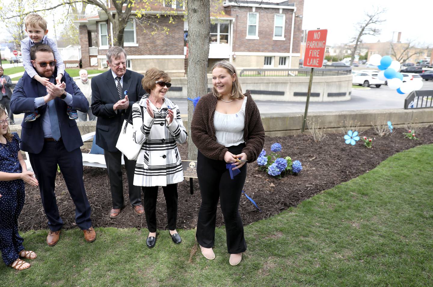 Ella Melei, 18, cuts the ribbon to a garden in honor of her mom, Debra Bree at the Kane County Child Advocacy Center in Geneva on Friday, April 29, 2022 as Debra’s parents,  Bill and Pat Bree, her husband, Joe Gay, and son, Liam Gay, look on. Bree, who was the executive director of the Kane County Child Advocacy Center, died Aug. 27, 2020 of colon cancer.