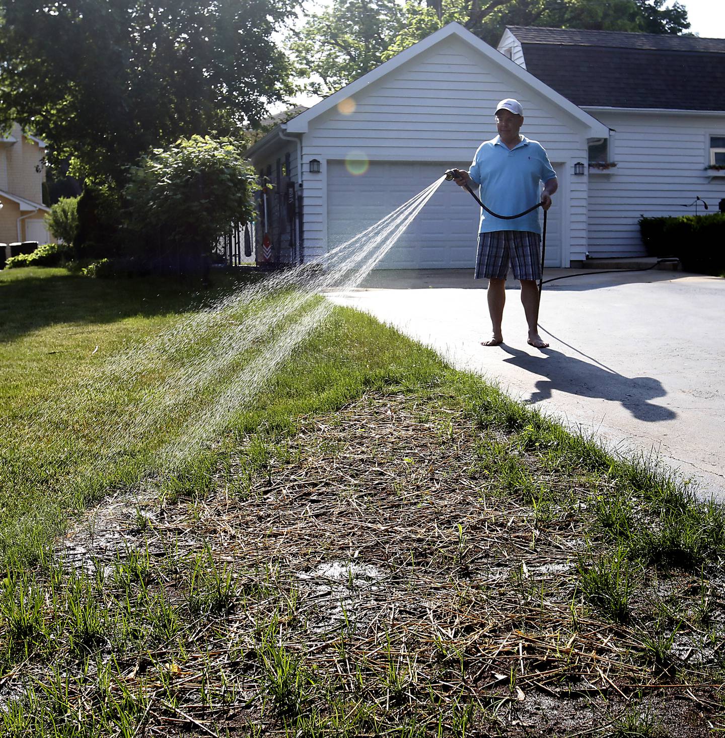 Mark Herdux waters a section of freshly planted grass on Thursday, June 2, 2023, at his home in Crystal Lake. A few weeks of little to no rain has created drought-like conditions in the area.