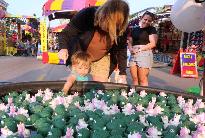 Jackson Mettler, 2, from Sycamore, tries to pick a good duck for a prize at Genoa Days, Wednesday, June 7, 2023, in downtown Genoa. The festival continues through Saturday.