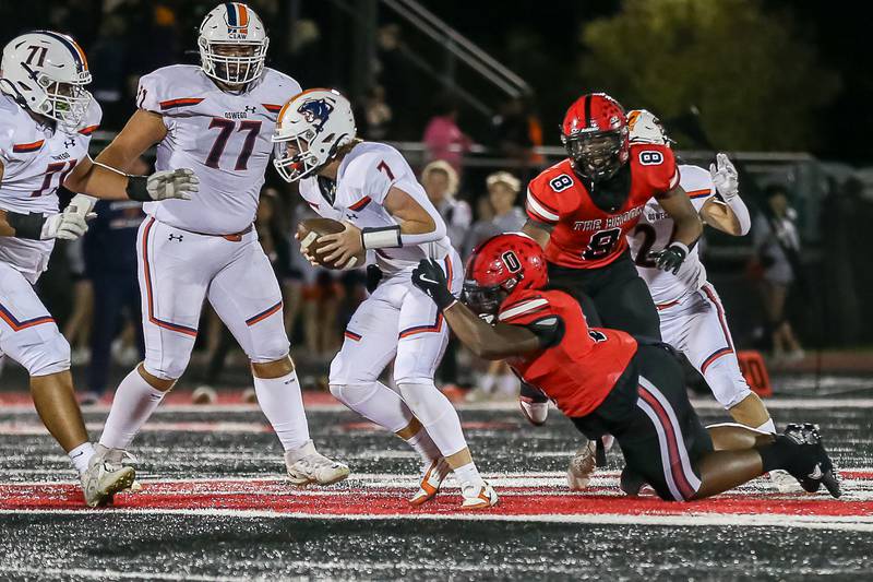 Bolingbrook's Jayceon Toney (0) pressures Oswego's Brett Connolly (7) during a football game between Oswego at Bolingbrook on Friday, Oct 4th, 2024  in Bolingbrook.