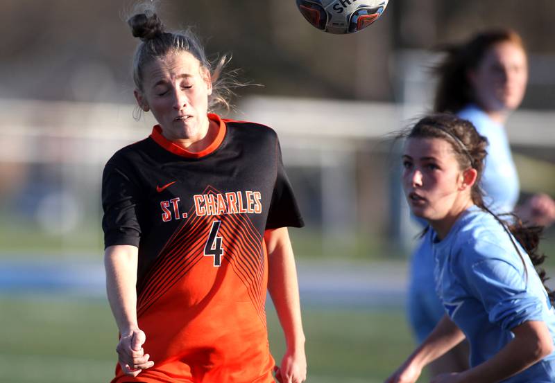 St. Charles East’s Grace Williams heads the ball during a Tri-Cities Night game against St. Charles North at Geneva High School on Tuesday, April 26, 2022.