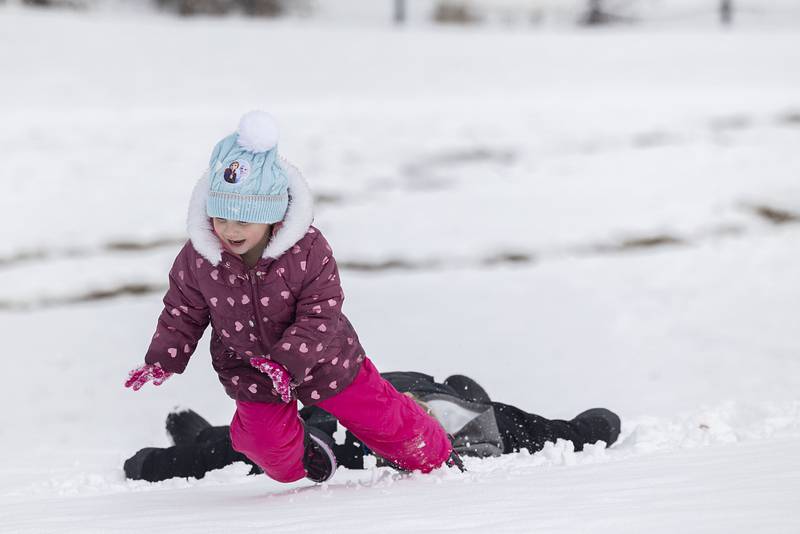Kinsley Kibodeaux, 4, and big brother Kellen, 10, make snow angels while hitting the sledding hill at Sinnissippi Park on Wednesday, Jan. 25, 2023 in Sterling.