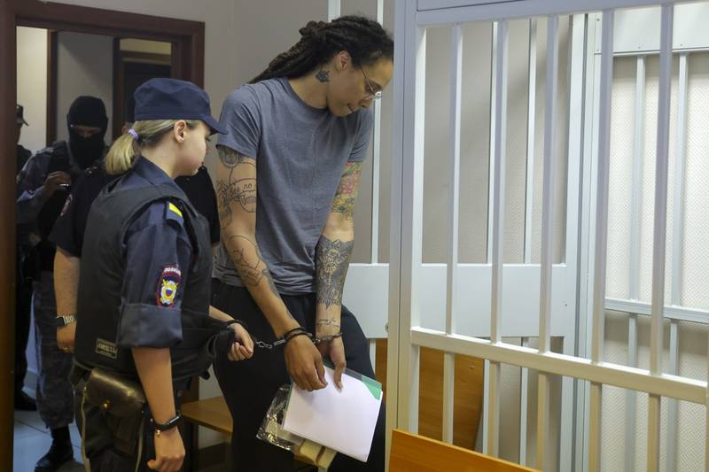 WNBA star and two-time Olympic gold medalist Brittney Griner, right, enters a cage in a courtroom prior to a hearing in Khimki just outside Moscow, Russia, Thursday, Aug. 4, 2022. Closing arguments in Brittney Griner's cannabis possession case are set for Thursday, nearly six months after the American basketball star was arrested at a Moscow airport in a case that reached the highest levels of US-Russia diplomacy. (Evgenia Novozhenina/Pool Photo via AP)