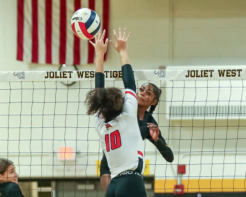 Joliet West's Iyonna Pike (8) hit a shot just past Bolingbrook's Bianca Fefee (10) during regional final volleyball match between Bolingbrook at Joliet West.  Oct 26, 2023.