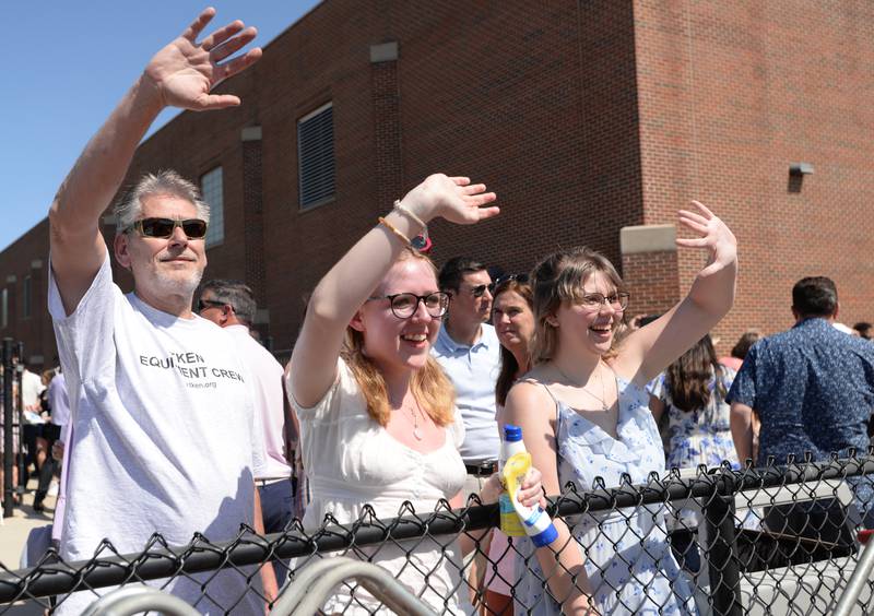 Eric Sale, Emma Sale and Ashley Hixon of Lisle wave to congratulate his daughter after the Downers Grove North graduation ceremony Sunday May 21, 2023.