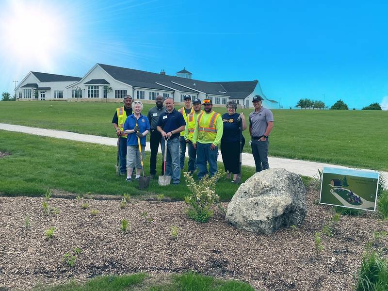 A planting crew for new pollinator garden at Parisek Park is photographed. From left to right: Wesley Peete, Karen Hutchings, Dan Ruggles, Scott Crowe, Colin Riley, Alex Gilland, Ben Schnulle, Monique Mahon, and Jason Irving. Irving is Huntley's assistant director of public works and engineering, Mahon and Hutchings are with the Rotary Club of Huntley, and the others are with the Huntley Park District.