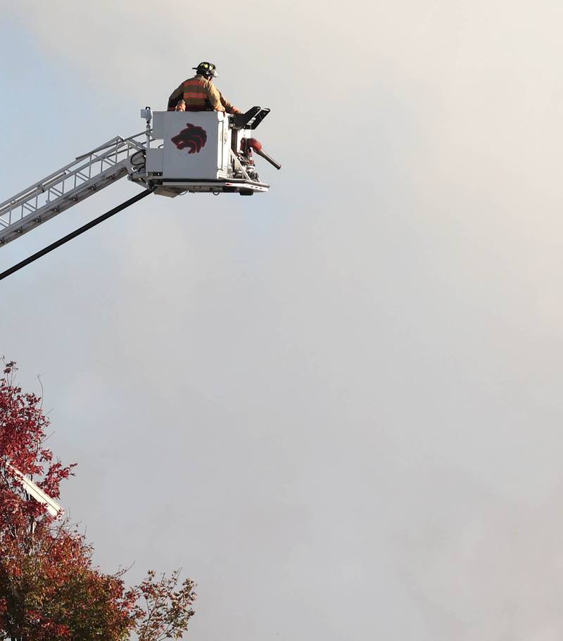 A Shabbona fire Department ladder truck crew overlooks the smoldering remnants of a house Tuesday, Oct. 17, 2023, after an explosion at the residence on Goble Road in Earlville.