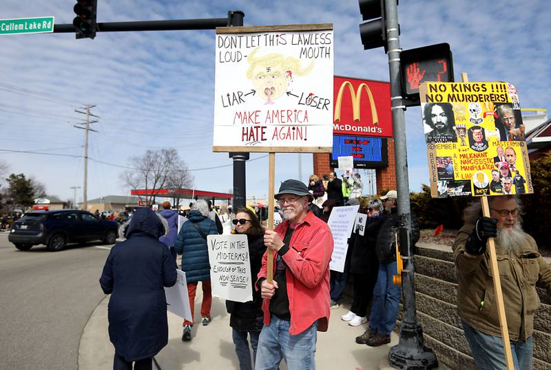 Bob Orvis, (center) hold his sign as he joins protesters lining State Route 31 near the intersection of McCullom Lake Road in McHenry to protest their discontent with President Donald Trump and his administration's policies on Saturday, March 28, 2026, during the McHenry County No Kings Protest. According to an organizer, over 4,000, people took part in the protest.