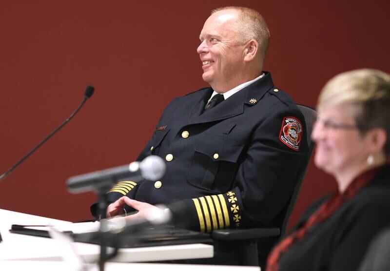 Acting DeKalb Fire Chief Michael Thomas smiles as city manager Bill Nicklas reads Thomas' career accomplishments prior to being sworn in as the city's new full-time fire chief Monday, April 11, 2022, during the DeKalb City Council meeting at the library. Thomas has been serving as the acting chief since the retirement of former chief Jeff McMaster in November.