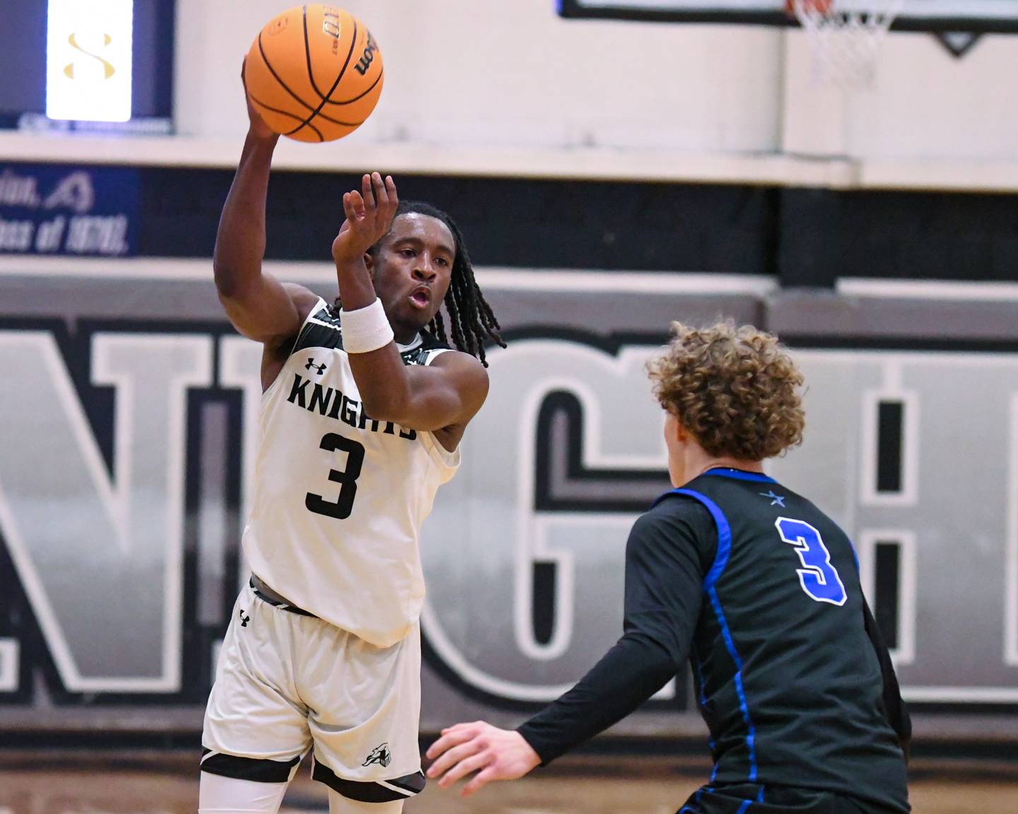 Kaneland's Marshawn Cocroft, left, passes the ball to a teammate while being defended by St. Charles North's Nathan Chappel (3) during the game on Wednesday Jan. 14, 2026, held at Kaneland High School.