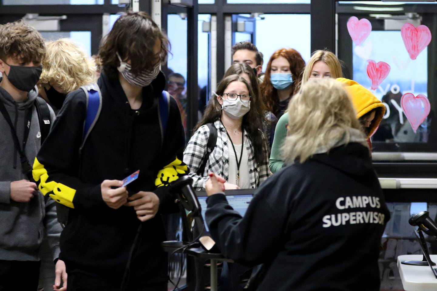 Students filter through doors painted with hearts and welcoming greetings during the first day back to hybrid learning in CUSD-158, incorporating a split between remote and in-person learning, on Monday, Jan. 25, 2021 at Huntley High School in Huntley.