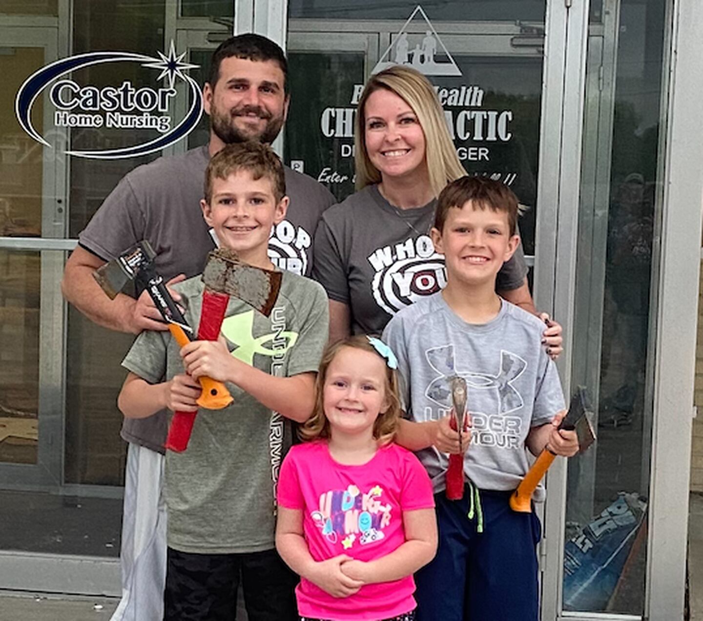 Josh Coward and his family pos3 with some throwing hand axs, part of the new business  — Whoop Your Axe Mobile Axe Throwing — that plans a July opening.