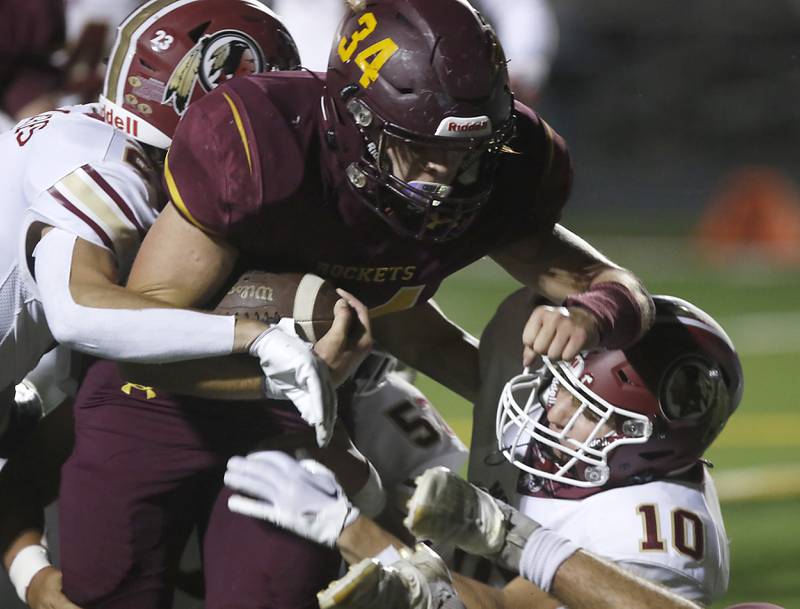 Richmond-Burton's Toby Quentrall-Quezada, center, carries Morris’ AJ Zweeres, left, and Sam Mateski, right as he fights for extra yards during a Kishwaukee River Conference / Interstate 8 Conference crossover football game Friday, Sept. 30, 2022, between Richmond-Burton and Morris at Richmond-Burton Community High School in Richmond.
