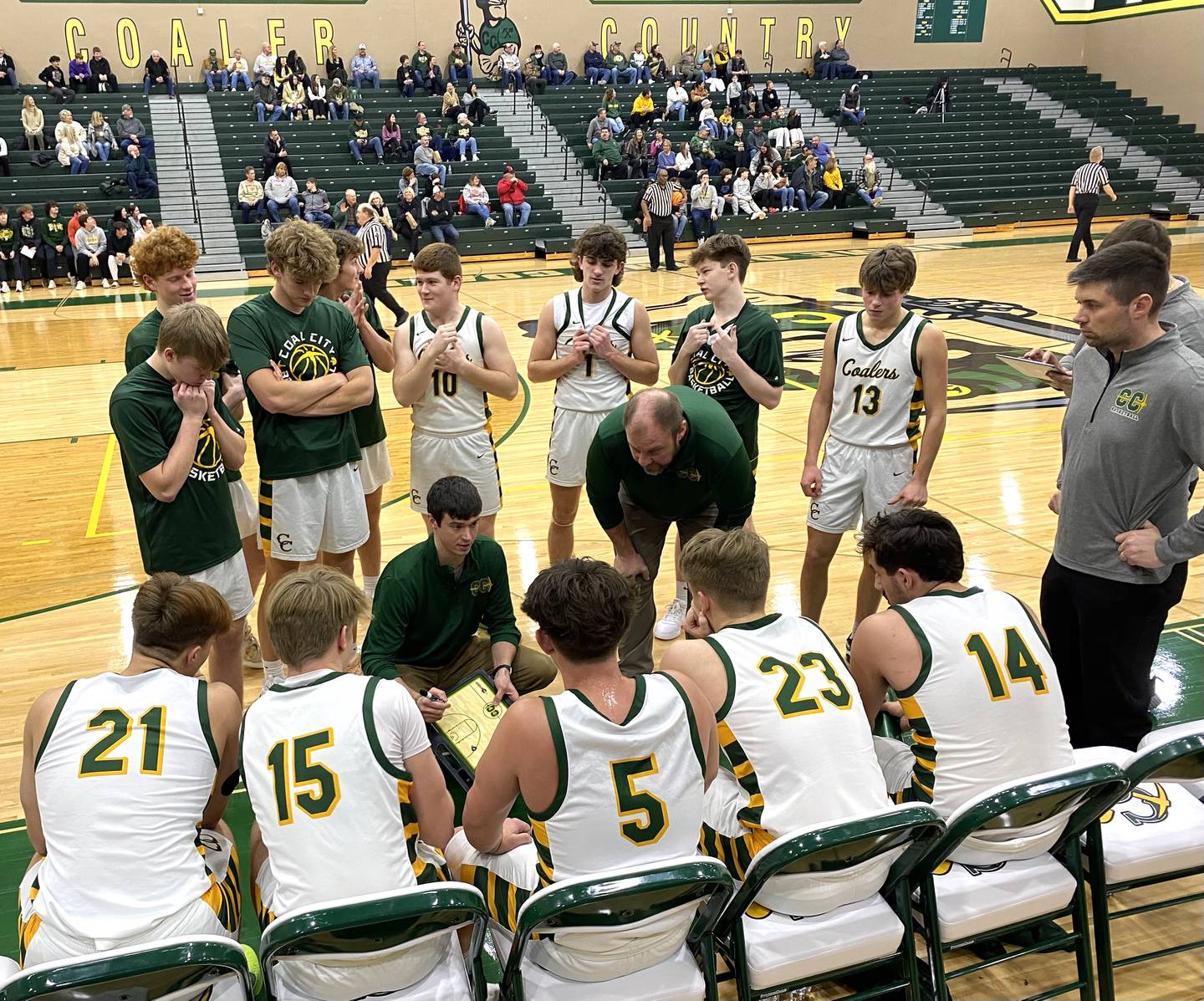 Coal City boys basketball coach Joe Micetich (crouching with clipboard in hand) talks to his Coalers during the first half of their game Tuesday, Jan. 28, 2025, in Coal City.