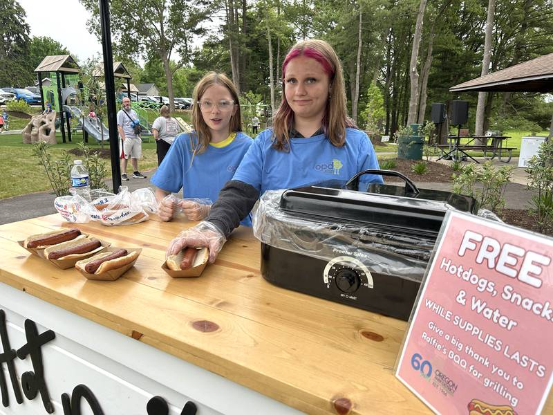 Thirteen-year-olds Aubrey Jenkins (left)  and Maddalynn Kochsmeier were two of the volunteers who served hot dogs during the Oregon Park District's grand opening celebration for the newly upgraded Park East Inland Side recreation area on Monday, May 18, 2026.