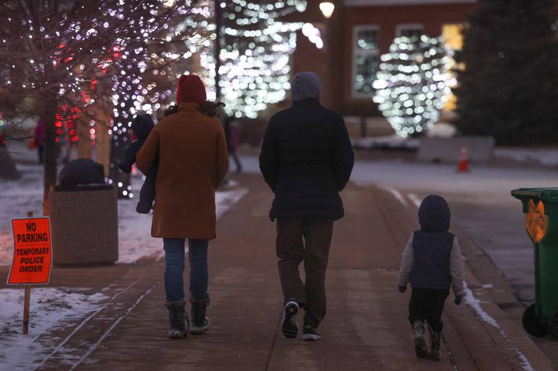 A family walks along the park path at New Lenox’s Christmas in the Commons.